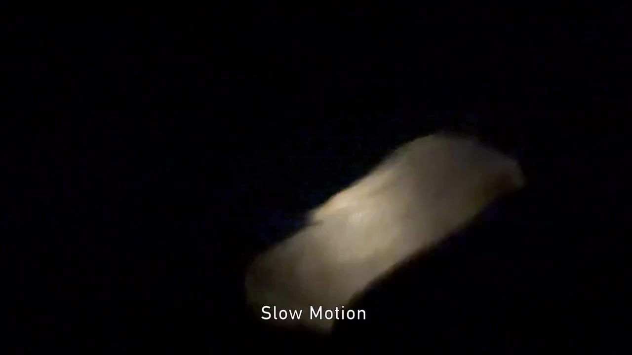 Still frame from the video: two quartz cobbles glowing where they’re rubbed together, in a darkened room.
